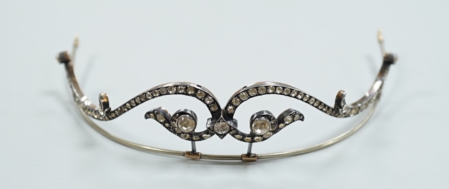 A 19th century, white and yellow metal paste cluster set tiara, width 13cm, the central stone with rose cut diamond chip spacers.